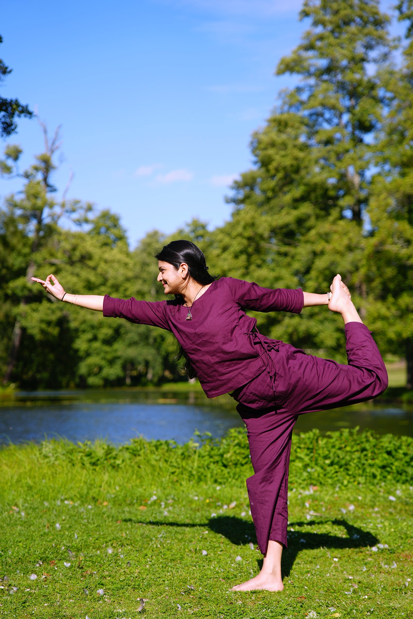 Woman in a standing dancer yoga pose, arm reaching forward