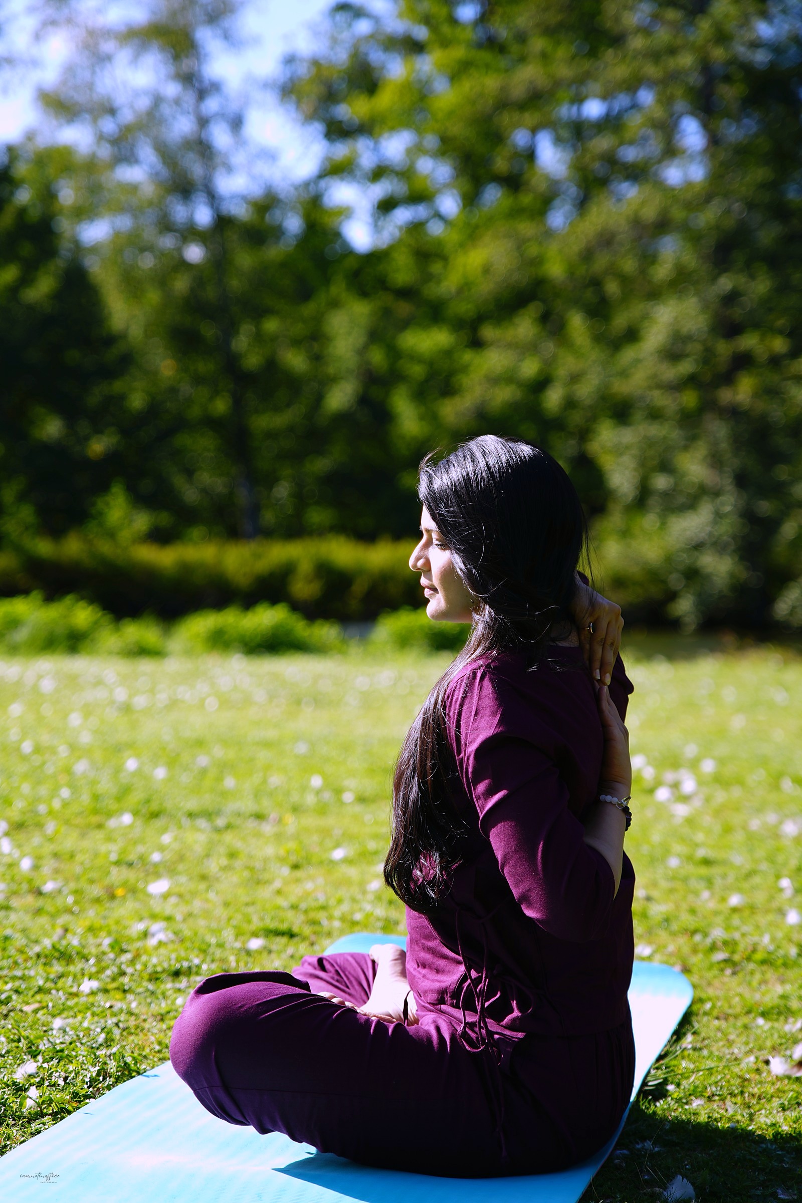 Woman sitting quietly in a sunlit park, profile view