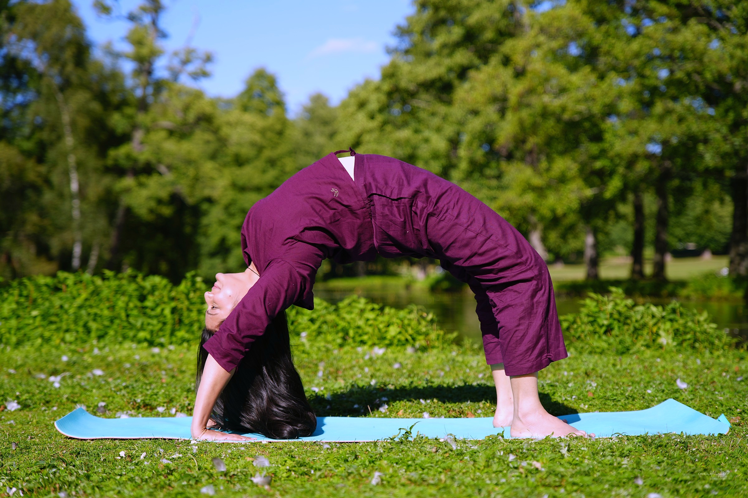 Woman in a wheel pose backbend on a yoga mat outdoors