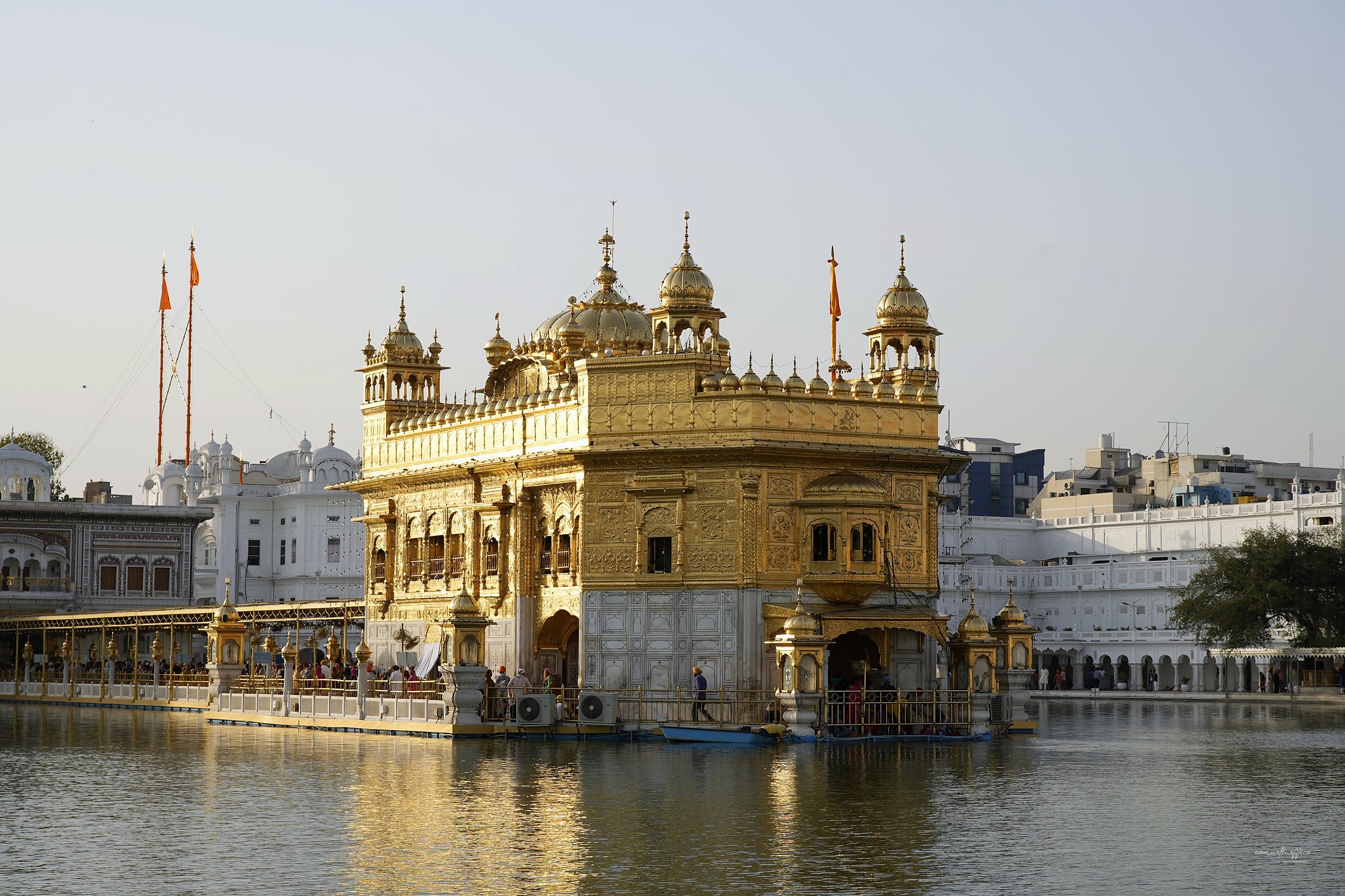 The Golden Temple reflected in its surrounding pool at golden hour