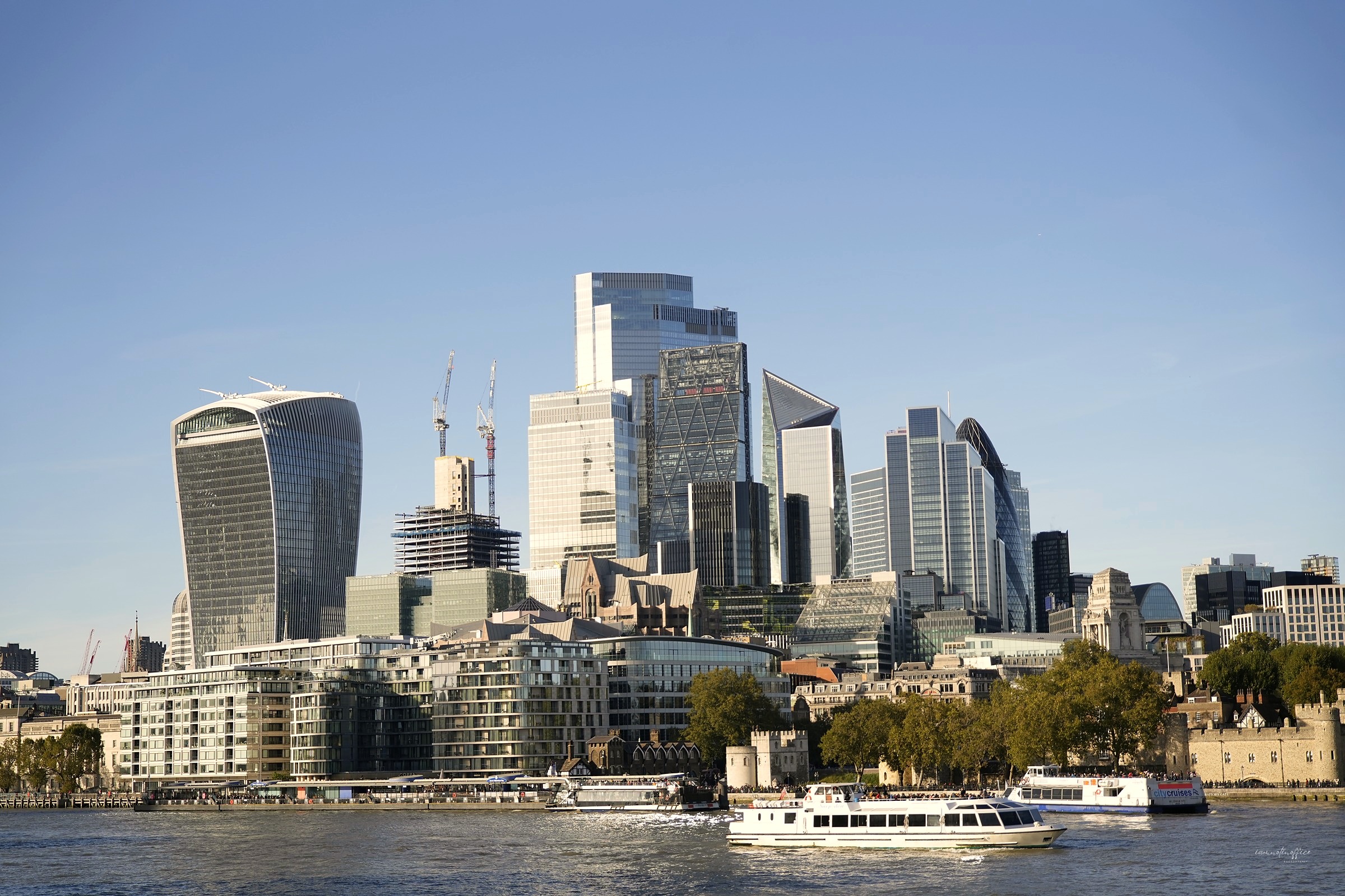 London skyline along the Thames with boats passing